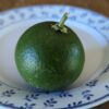 une lime japonaise verte sudachi sur une assiette