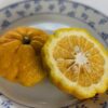 un fruit de Yuzu 30 coupé en deux sur une assiette